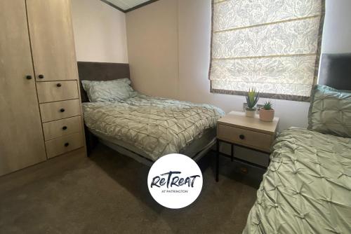a bedroom with two beds and a dresser and a window at ReTreat Breaks - 47 Park Lane in Patrington