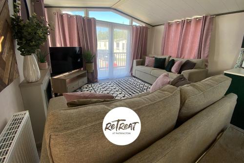a living room with a couch and a tv at ReTreat Breaks - 47 Park Lane in Patrington