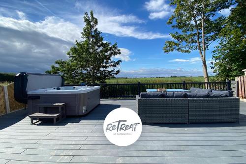 a patio with a hot tub and a table and chairs at ReTreat Breaks - 47 Park Lane in Patrington