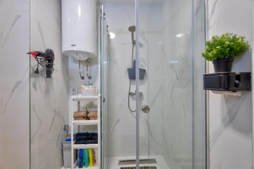 a shower with a glass door and a plant in a bathroom at Bambi S18 - Your New Family Story in Zlatibor