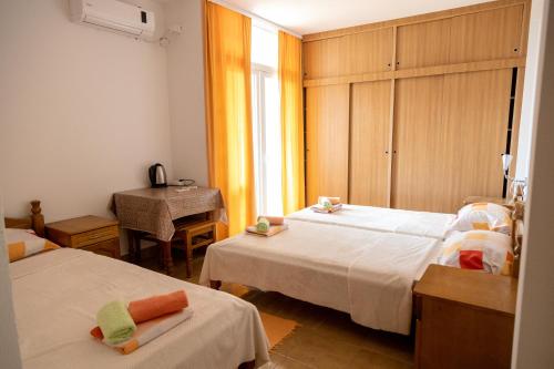 um quarto com 2 camas, uma mesa e uma janela em Apartments Hodžić em Ulcinj