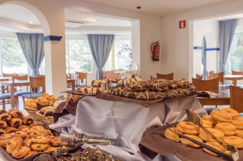 una tavola piena di diversi tipi di pane di Hotel El Pinar a Cala Llonga