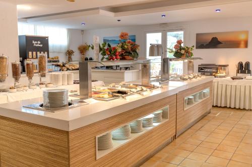 un ristorante con bancone di piatti e piatti di Hotel El Pinar a Cala Llonga