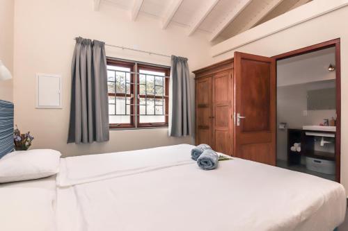 een slaapkamer met een groot wit bed en een raam bij ABC Lodges Curacao in Willemstad