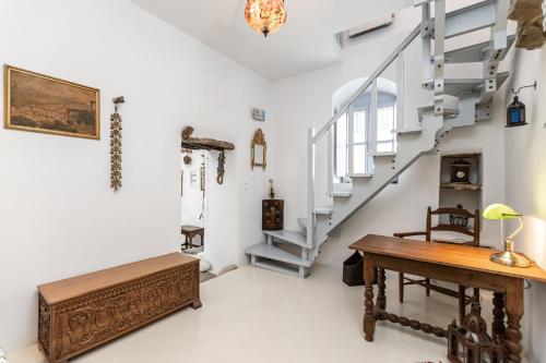 a room with a staircase and a wooden table at Old Mansion in Melanes in Mélanes