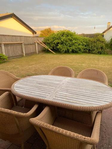 a table with four chairs and a table with at Fin ny moderniseret lejlighed i Skagen. in Skagen