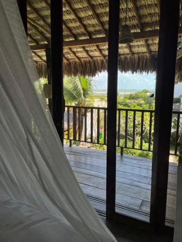 a bed in a room with a view of a deck at Casa da Gwen in Jericoacoara