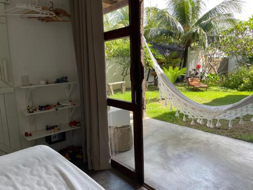 a bedroom with a hammock and a view of a yard at Casa da Gwen in Jericoacoara