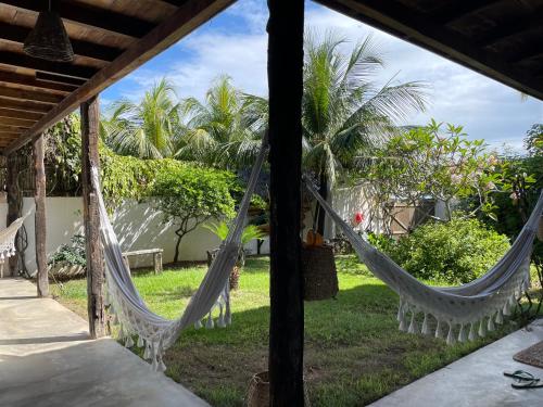 a view from the porch of a house with hammocks at Casa da Gwen in Jericoacoara