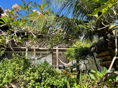 a building in the middle of a garden with trees at Casa da Gwen in Jericoacoara
