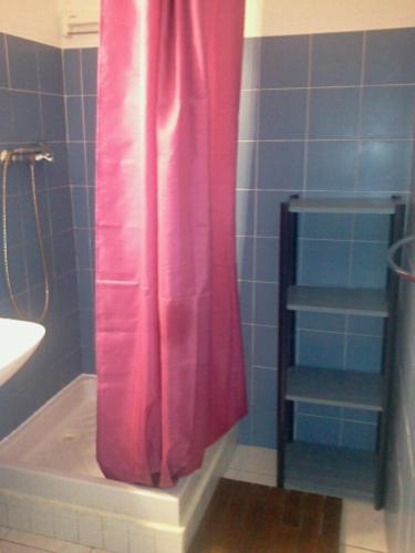 - un rideau de douche rose dans la salle de bains pourvue d'un lavabo dans l'établissement Appartement F1 Calvi à 150 mètres de la plage, à Calvi