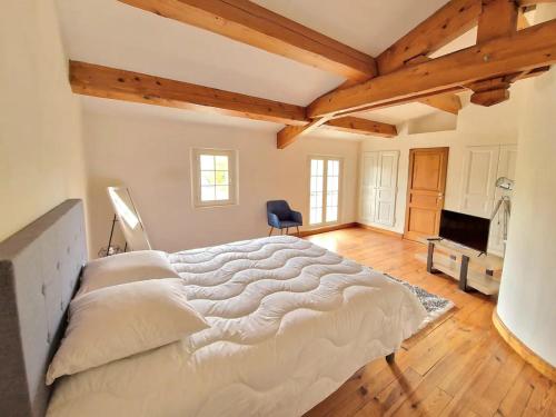 1 cama blanca grande en una habitación con techos de madera. en Villa Pio en Roquebrune-sur-Argens