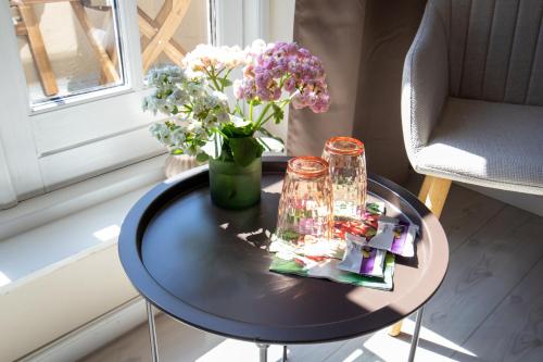 a table with a vase of flowers on it at Mosters Bed & Breakfast in Guldborg
