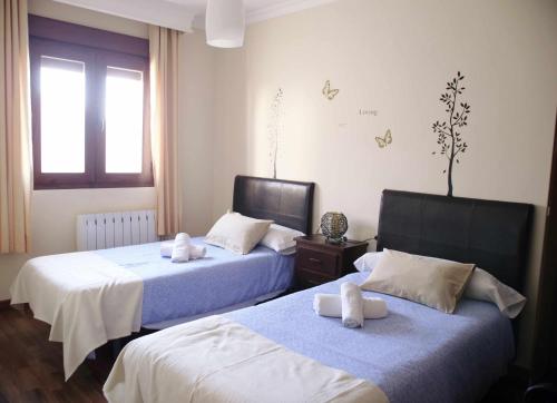 Dos camas en una habitación de hotel con toallas. en Apartamento Medina Las Eras, en Güevéjar