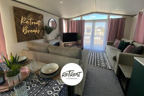 a living room with a couch and a table at ReTreat Breaks - 47 Park Lane in Patrington
