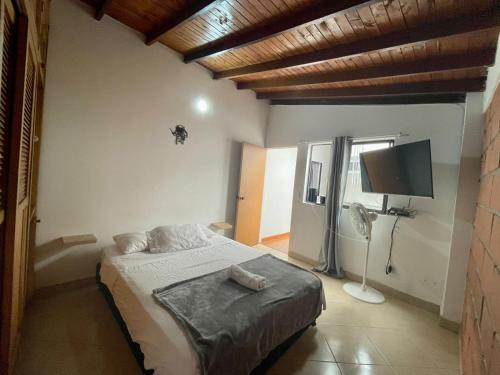 um quarto com uma cama e uma televisão de ecrã plano em HERMOSO APTO EN LAURELES em Medellín