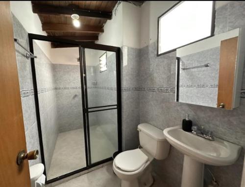 uma casa de banho com um chuveiro, um WC e um lavatório. em HERMOSO APTO EN LAURELES em Medellín