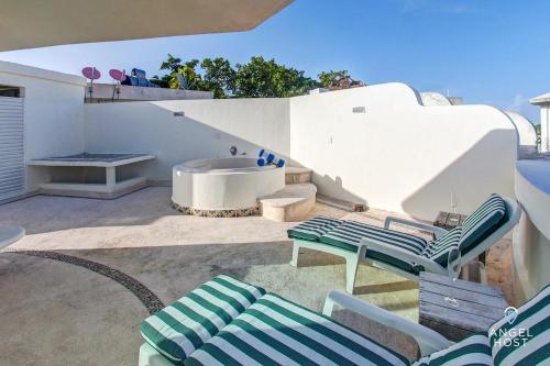un patio con 2 tumbonas y una bañera en PH with Private Rooftop on 5th by Mamitas Beach, en Playa del Carmen