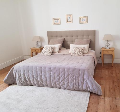 a bedroom with a large bed with two night stands at Domaine et Manoir du Picaud in Monestier