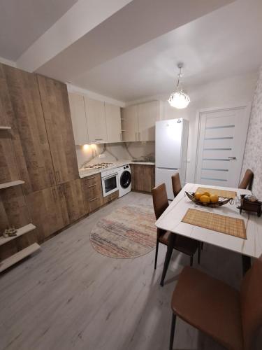 a kitchen with a table and chairs and a refrigerator at Chirie Apartament in Chişinău