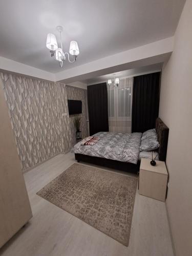 a bedroom with a large bed and a rug at Chirie Apartament in Chişinău