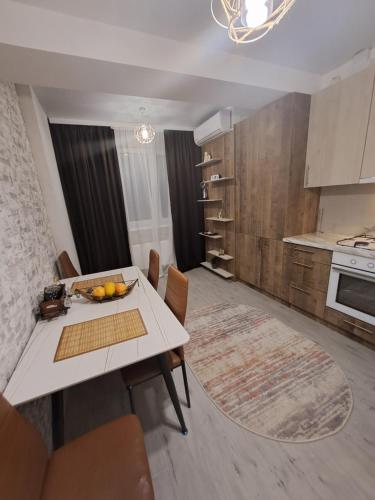 a kitchen with a white table and chairs in a room at Chirie Apartament in Chişinău