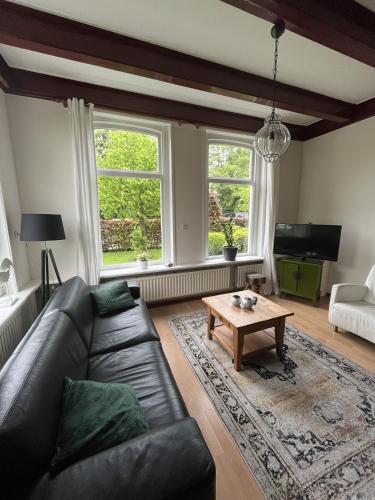 a living room with a leather couch and a coffee table at Vakantiehuisjes Marsherne in Poppingawier