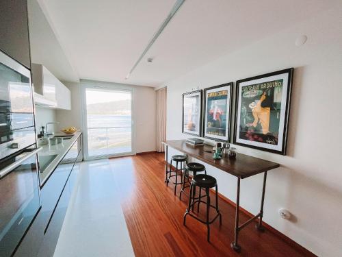 a living room with a table and some pictures on the wall at Just Like Home - Oceanside Walk in Caminha