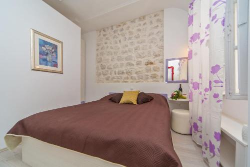 a bedroom with a bed and a tub in it at Apartments & Rooms Orlando in Dubrovnik