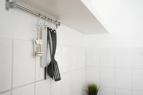 a group of utensils are hanging on a wall at Stadtoase Design Wohnung in der Altstadt in Koblenz