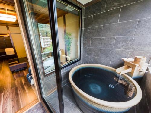 Habitación con baño con bañera azul grande. en LiVEMAX RESORT Kawaji en Nikko