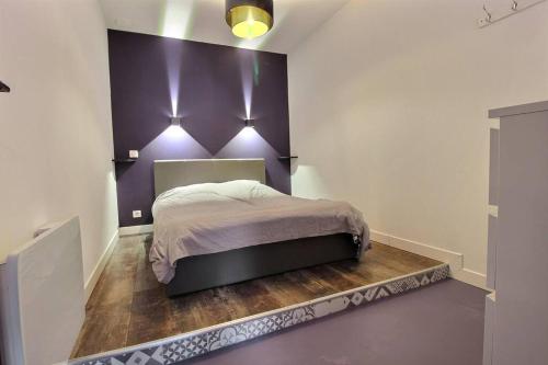 1 dormitorio con 1 cama con pared morada en Cosy d'Azur T2 centre historique-vieux port, en La Ciotat