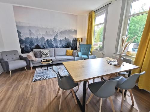 sala de estar con sofá, mesa y sillas en BohnApartments Zechenhaus - Balkon - gratis Parkplatz - WLAN - sehr ruhig - barrierearm, en Ilmenau