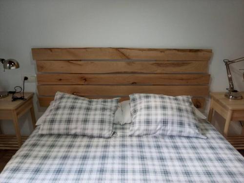 1 cama con sábanas y almohadas a cuadros en un dormitorio en FrantzunatxakVistas al mar EBI10012, en Bermeo