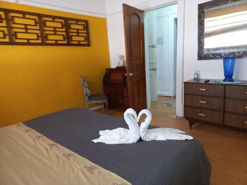 2 cigni bianchi seduti su un letto in una camera da letto di Departamento luxury Condesa a Città del Messico
