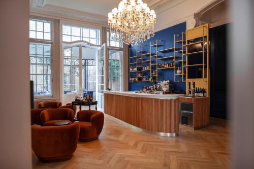 Cette chambre comprend un bar avec des chaises et un lustre. dans l'établissement MAISON RENARD, à Béthune