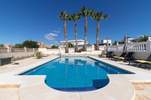 een zwembad met palmbomen op de achtergrond bij Casa Julia in Busot
