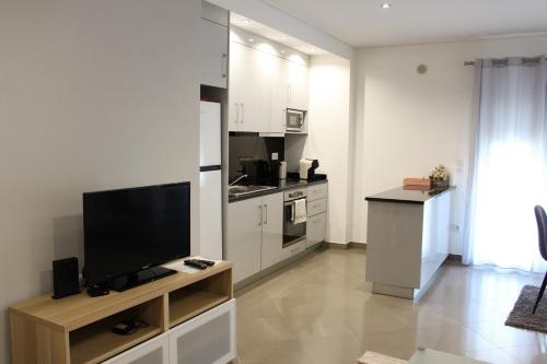 sala de estar con TV de pantalla plana y cocina en Apartamento Fátima Sanctuary en Fátima