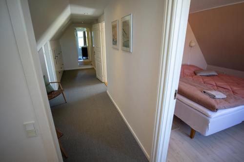 a small bedroom with a bed and a hallway at Mosters Bed & Breakfast in Guldborg