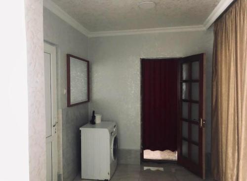 um quarto com um frigorífico e uma cortina vermelha em Villa Lizzy em Batumi