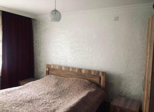 sypialnia z łóżkiem i białą ścianą w obiekcie Villa Lizzy w mieście Batumi