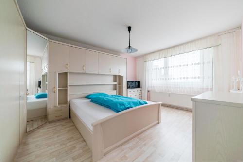 a white bedroom with a bed and a bathroom at Private Apartment in Hannover