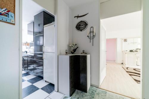 cocina con nevera y suelo blanco y negro en Private Apartment, en Hannover