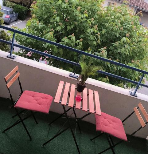 Sur le balcon, vous trouverez deux chaises et une table avec une plante en pot. dans l'établissement Sublime appartement avec balneo, à Toulouse