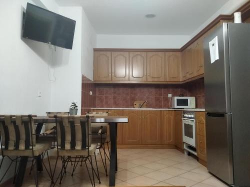 eine Küche mit einem Tisch mit Stühlen und einem Kühlschrank in der Unterkunft Baou House 1 in Metsovo