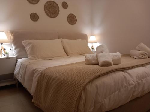 a bedroom with a large white bed with towels on it at Ammos Aetos apartment in Karistos