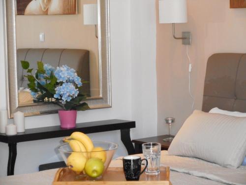 a table with a bowl of fruit and a mirror at Villa Fun & Sun in Limenaria