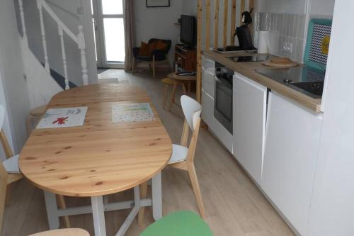 - une petite cuisine avec une table en bois dans l'établissement Maison cosy à 2 min de la plage et des commerces, à Berck-sur-Mer