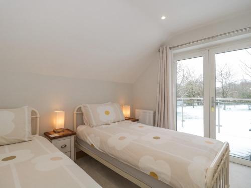 a bedroom with two beds and a large window at The Winning Post in Bruton