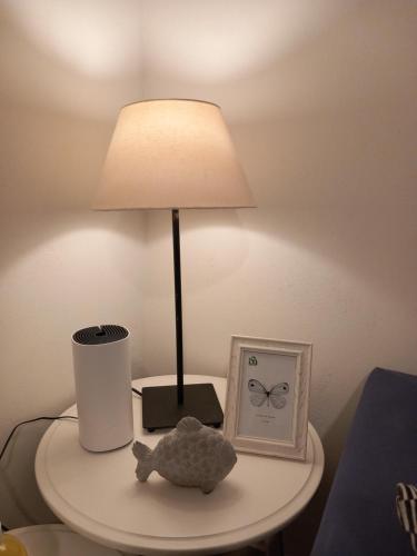 a lamp on a table with a stuffed animal and a clock at Ammos Aetos apartment in Karistos
